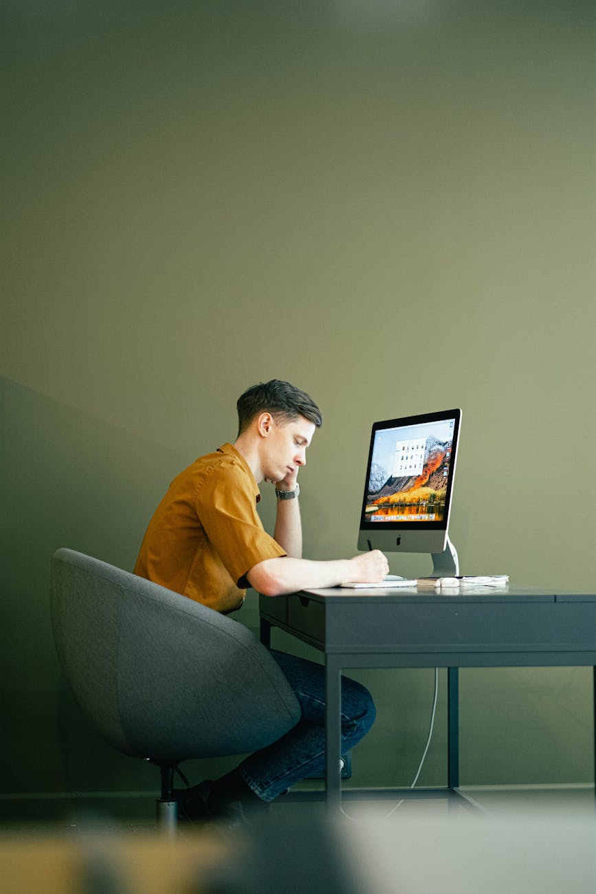 man sitting on a chair in front of a computer